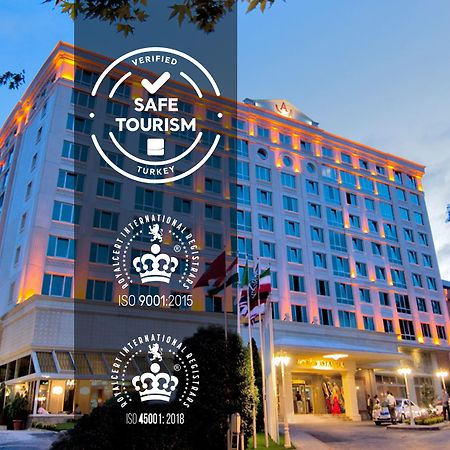 Akgun Istanbul Hotel Exterior foto The image shows a large hotel building, which is well-lit with warm lighting on its facade. Several logos are displayed prominently on the image, indicating that the hotel has been verified for "Safe Tourism" in Turkey. Additionally, there are two ce