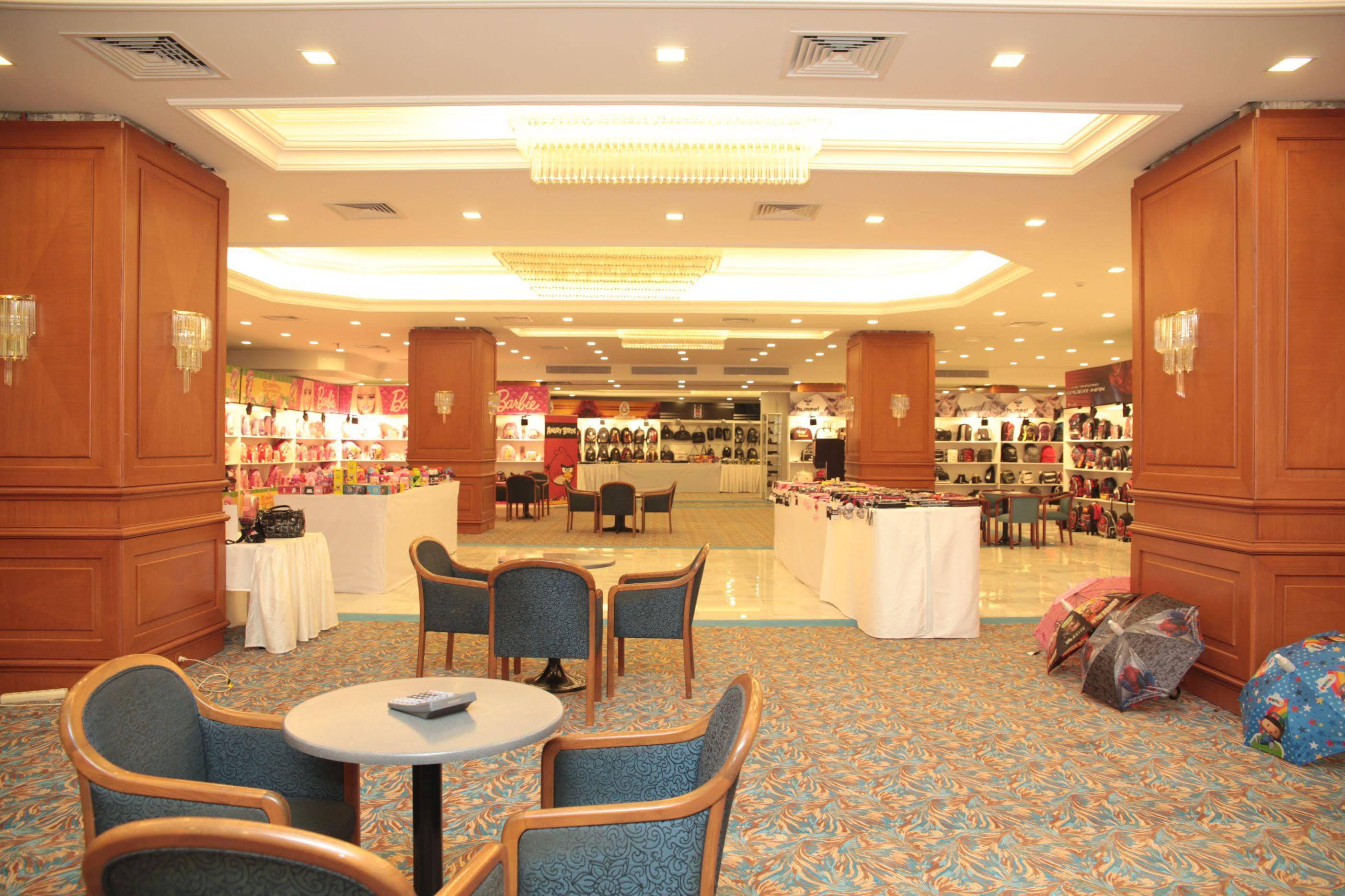 Akgun Istanbul Hotel Exterior foto The photo shows a spacious indoor area, likely an exhibition or trade show space. On one side, there are display stands with various products, possibly bags or accessories, arranged neatly. The lighting is bright, enhancing the atmosphere. In the for