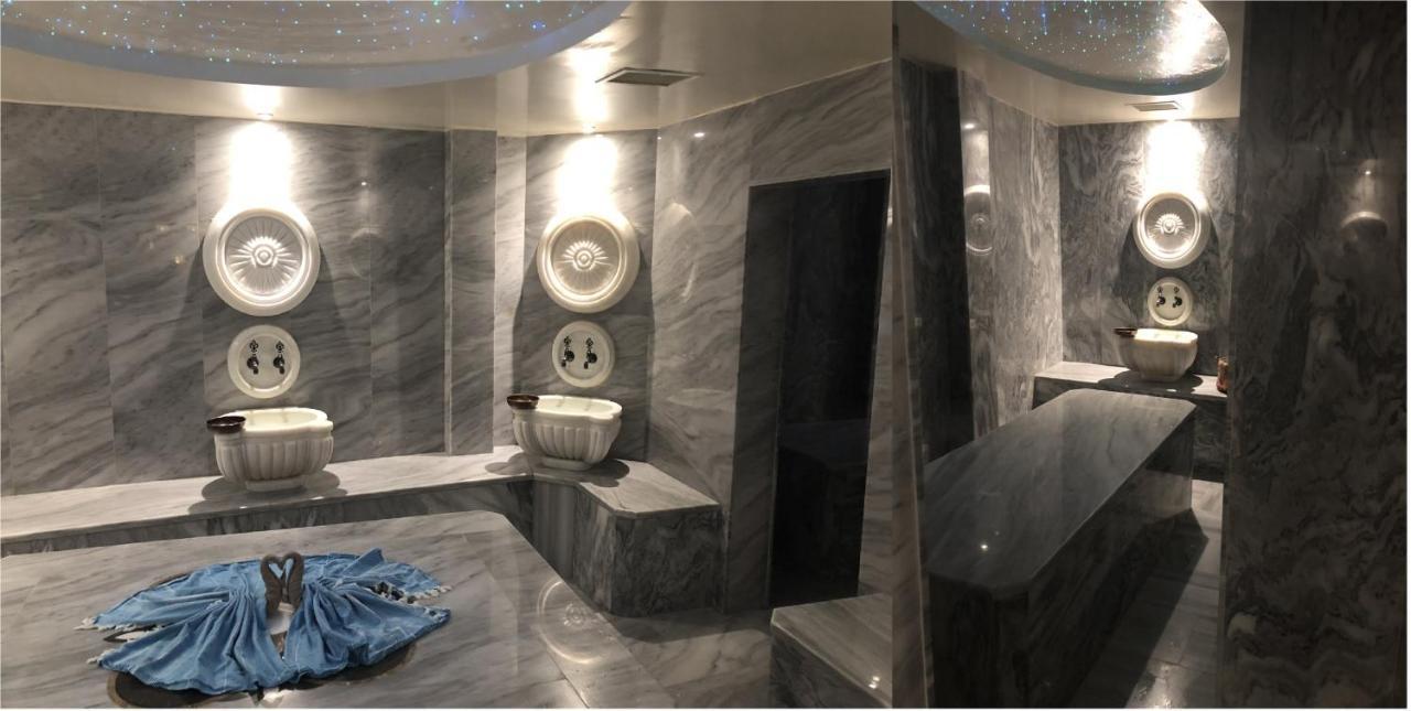 Akgun Istanbul Hotel Exterior foto The photo shows a luxurious bathroom or spa area featuring elegant marble surfaces. The walls and flooring are adorned with a polished gray marble finish. There are unique decorative elements, including artistic wall features and basins. The lighting