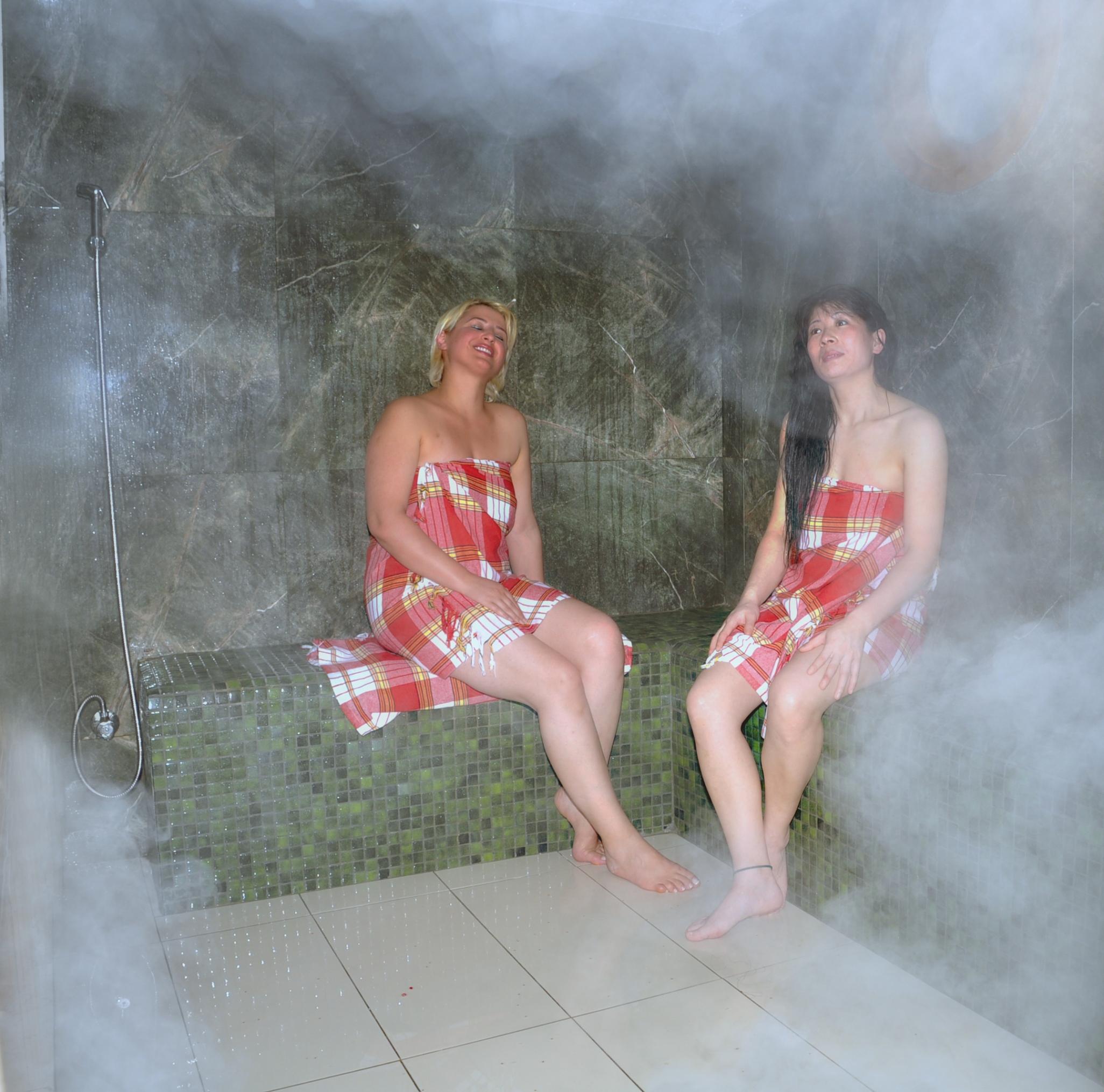 Akgun Istanbul Hotel Exterior foto The photo depicts two women seated in a steam room. They are wearing matching plaid-patterned towels. The atmosphere is steamy and somewhat obscured, adding a sense of relaxation and warmth. The background appears to be made of stone or tiles, typica