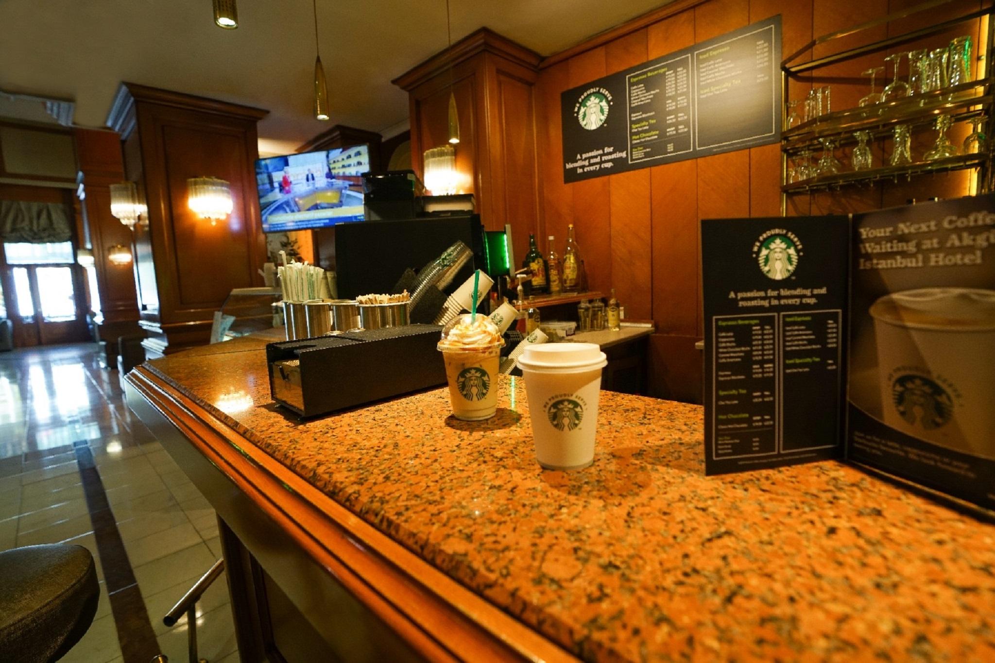 Akgun Istanbul Hotel Exterior foto The photo shows the interior of a Starbucks coffee shop. There's a wooden counter with a polished surface, where two coffee cups are placed—one appears to be a disposable cup, while the other is a more decorative cup. Behind the counter, there are va