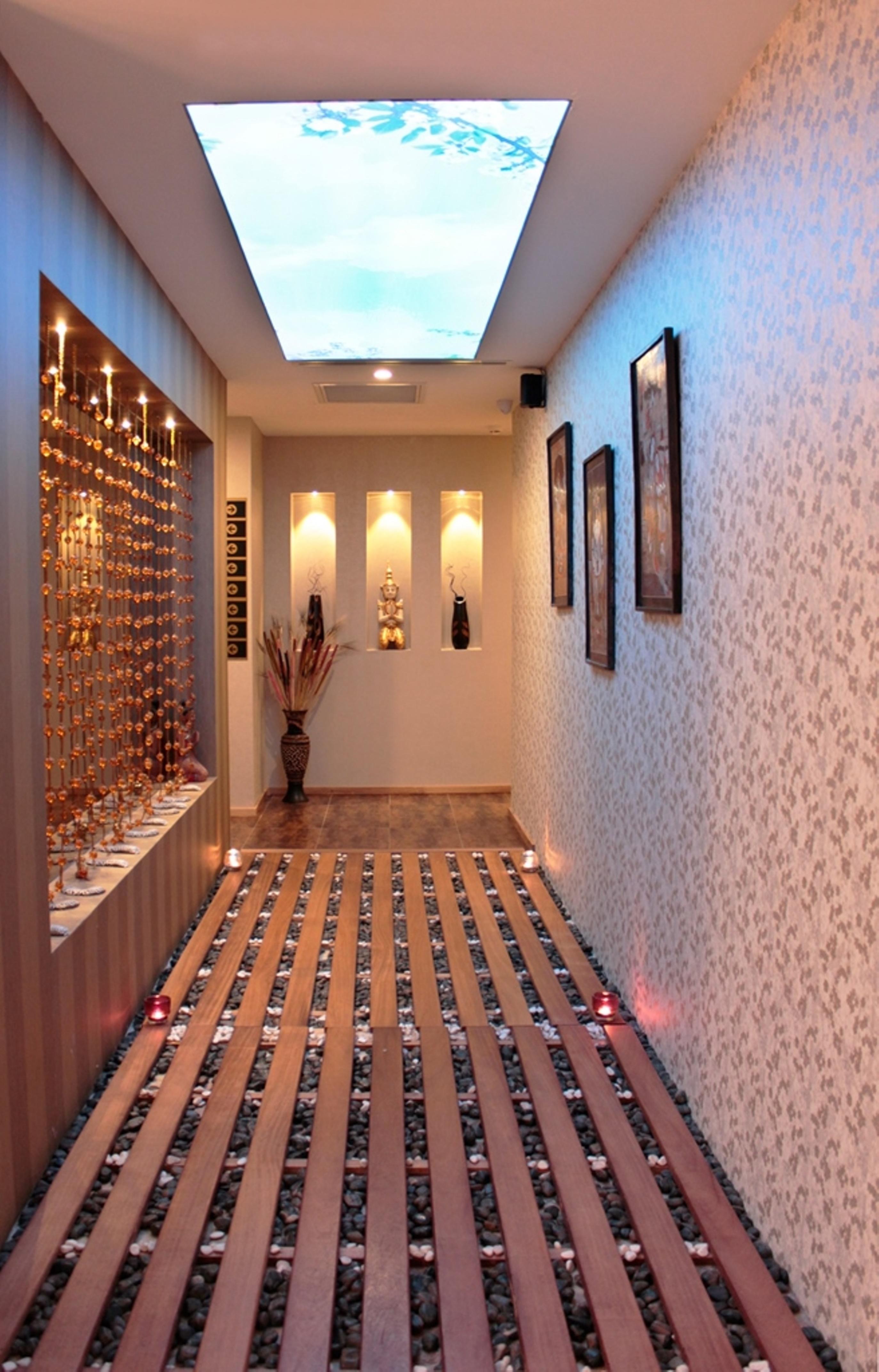 Akgun Istanbul Hotel Exterior foto The photo shows a narrow hallway that features an elegant and inviting design. On one side, there is a display with hanging decorative items or ornaments, creating a visually appealing focal point. The opposite wall has recessed areas with lit fixtur