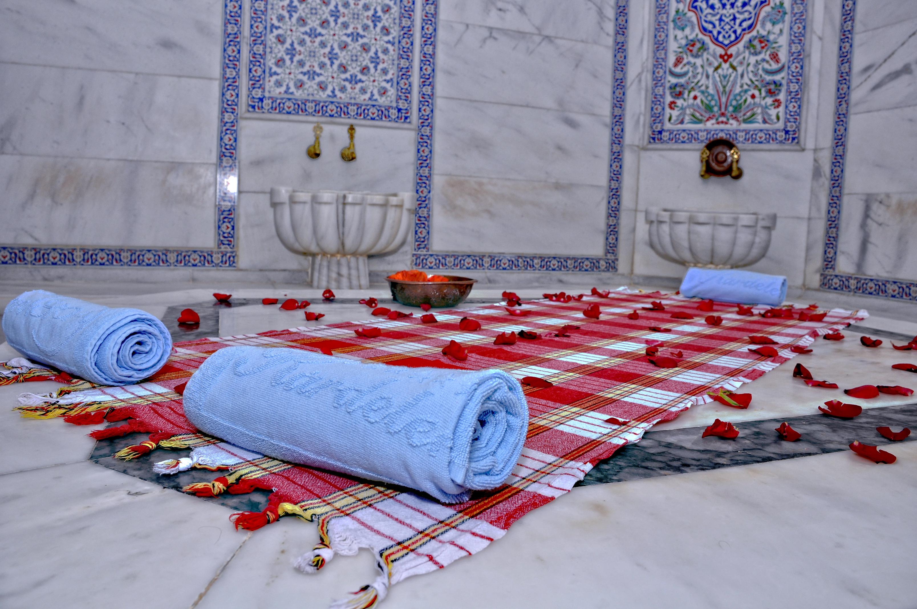 Akgun Istanbul Hotel Exterior foto The photo shows a serene and luxurious setting typical of a spa or a hammam. It features a marble floor with decorative tiles on the walls. There are two rolled blue towels arranged neatly on a patterned cloth laid out on the floor. The area is adorn