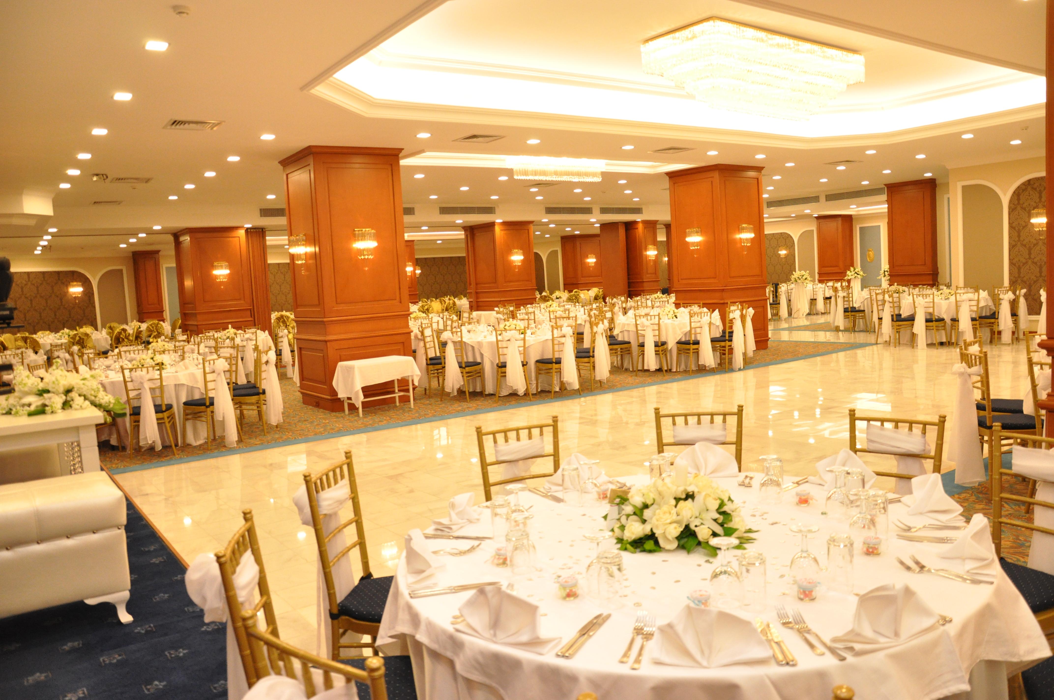 Akgun Istanbul Hotel Exterior foto The photo shows an elegant banquet hall set up for an event, such as a wedding or formal gathering. The room features well-decorated tables with white tablecloths and centerpieces consisting of flowers. There are numerous tables arranged throughout t