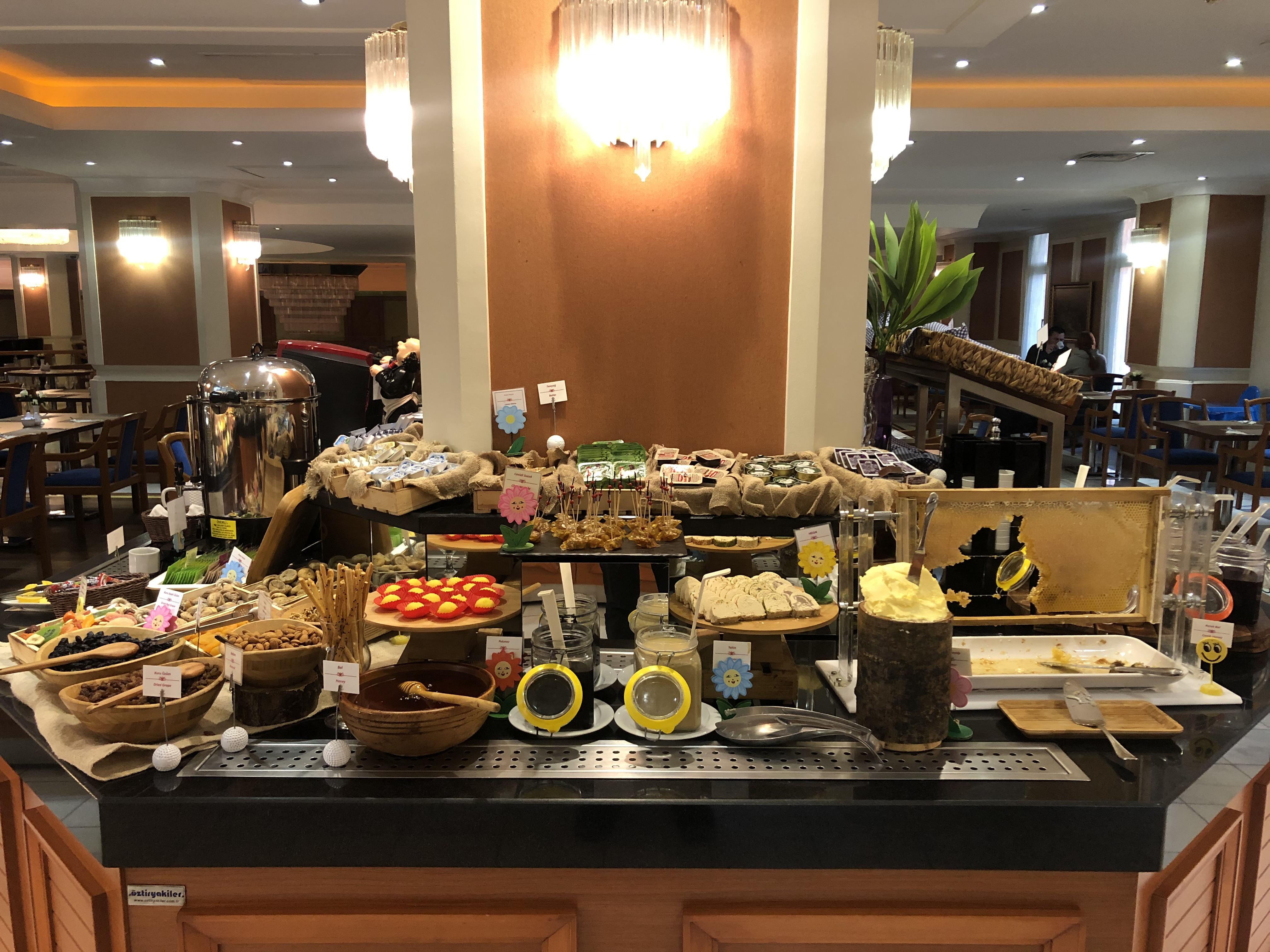 Akgun Istanbul Hotel Exterior foto The photo shows a buffet table set up in a restaurant. It features a variety of food items, including an assortment of pastries, snacks, and fruits. There are decorative bowls filled with food items, vibrant displays of sliced fruit such as oranges, 