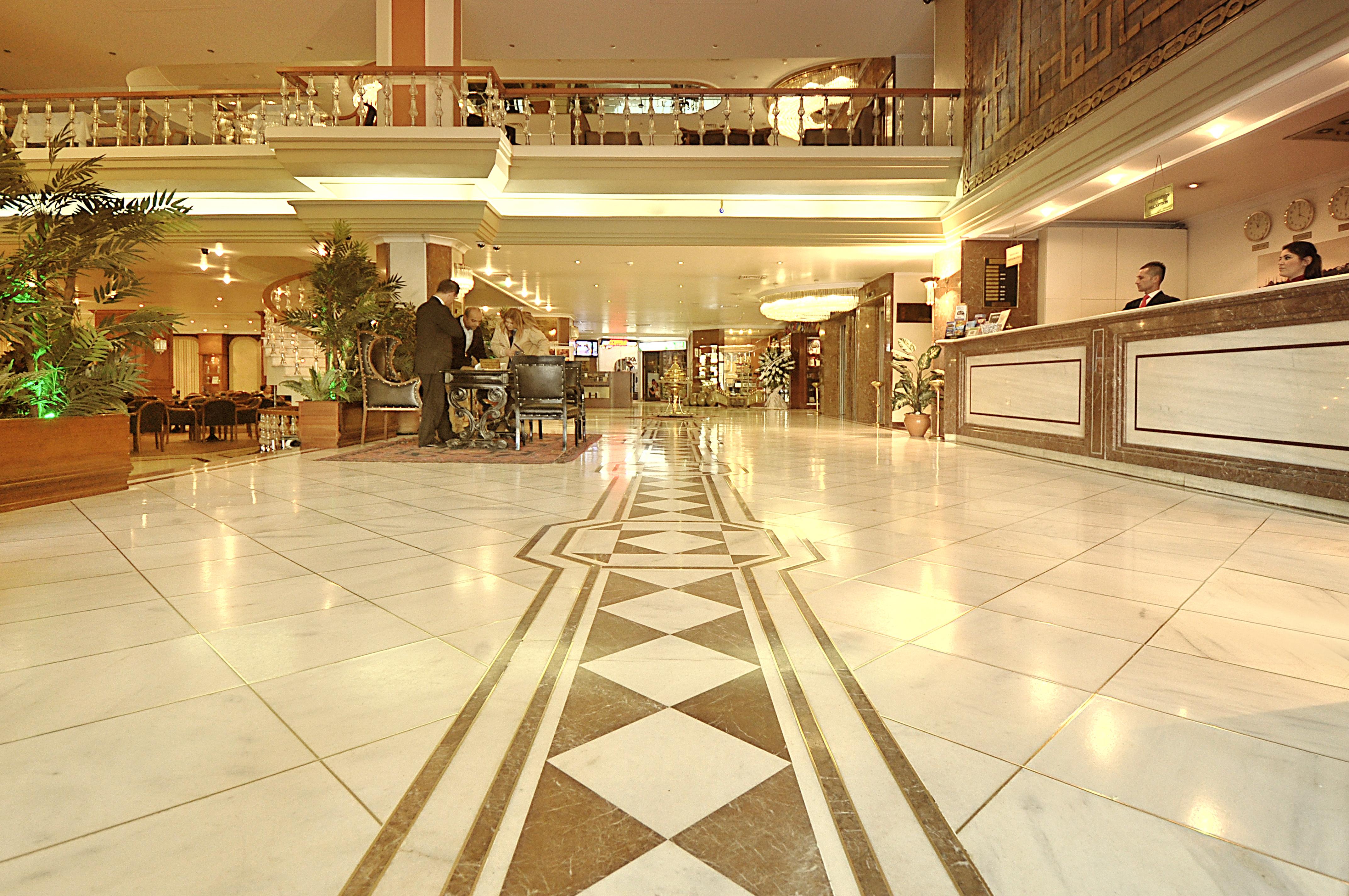 Akgun Istanbul Hotel Exterior foto The image shows the interior of a hotel lobby. The space features elegant marble flooring with a decorative pattern. There are some potted plants around the area, which adds a touch of greenery. In the background, you can see a reception desk where a