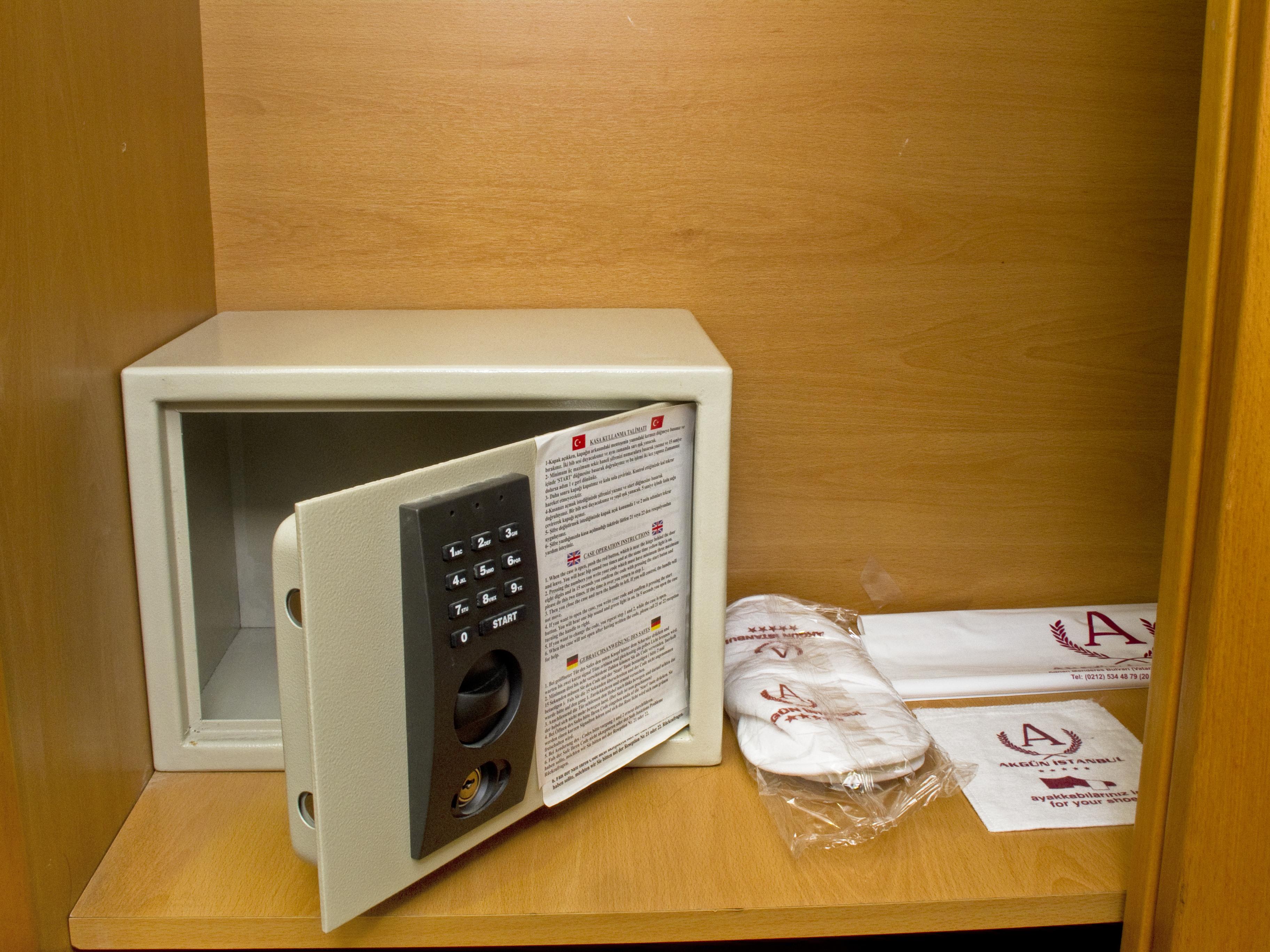 Akgun Istanbul Hotel Exterior foto The photo shows a small safe that is open with its door ajar. The safe features a numeric keypad for entering codes. Next to the safe, there are a couple of slippers packaged in plastic, along with some neatly folded towels. The background consists o