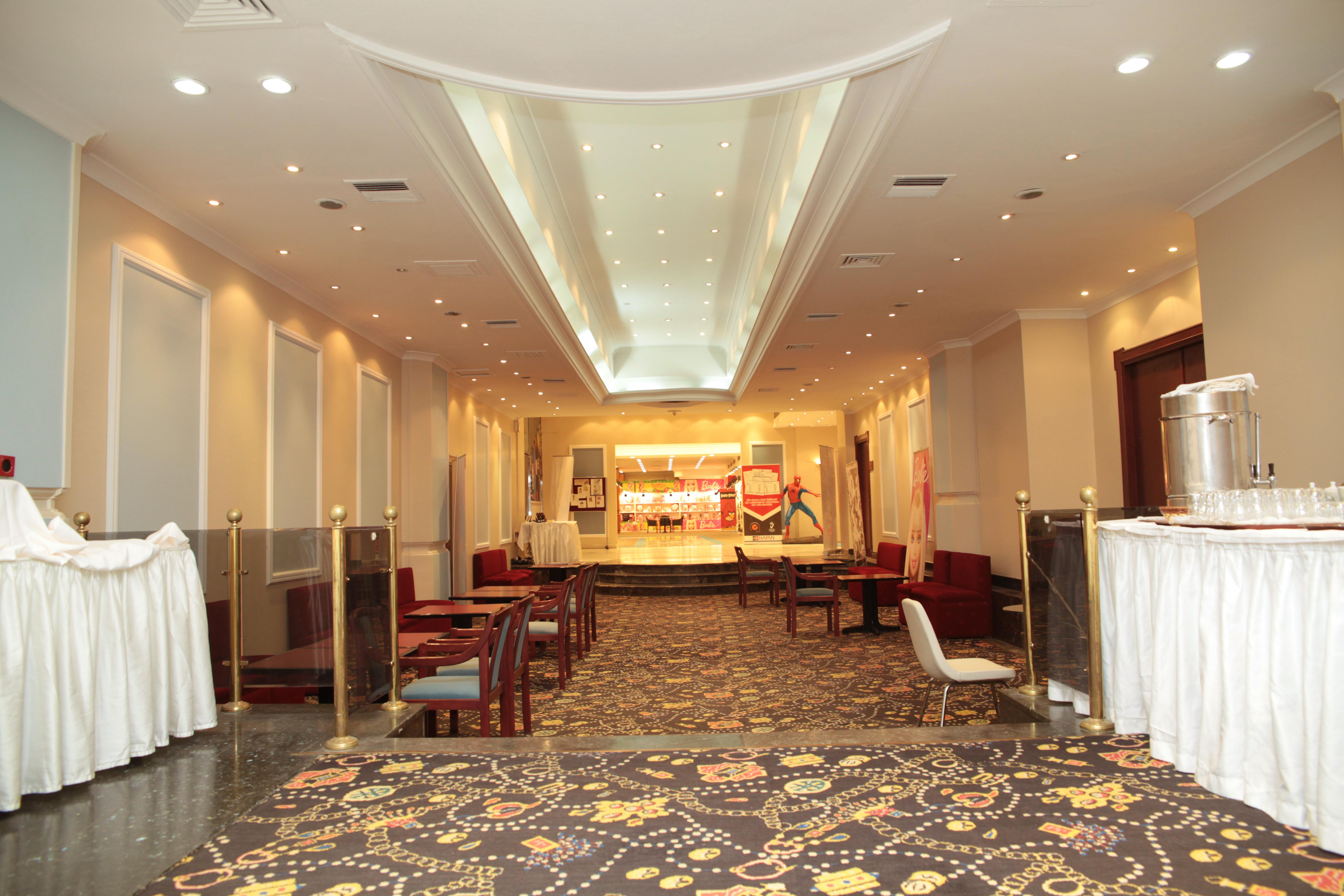 Akgun Istanbul Hotel Exterior foto The photo shows the interior of a well-decorated venue, likely intended for events or gatherings. There is a spacious hallway with a patterned carpet and a variety of seating arrangements, including chairs and sofas. The lighting is soft and ambient,