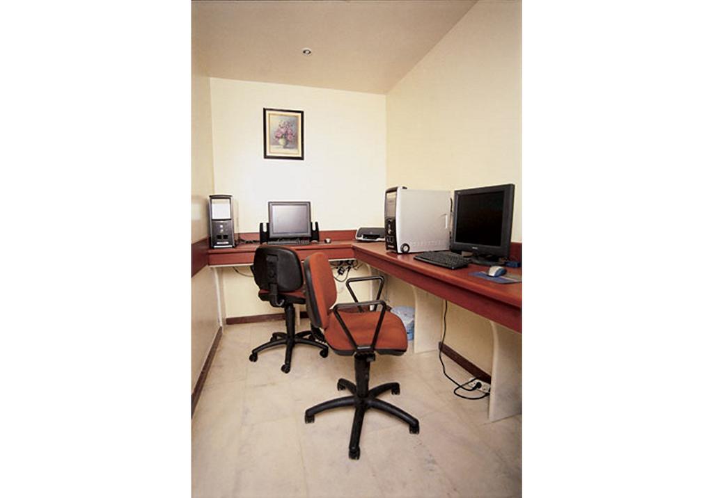 Akgun Istanbul Hotel Exterior foto The photo shows a small office space with two computer desks. Each desk has a desktop monitor and a chair. The chairs are on wheels and have a swivel design. The room has light-colored walls and a simple decorative picture hung above one of the desks